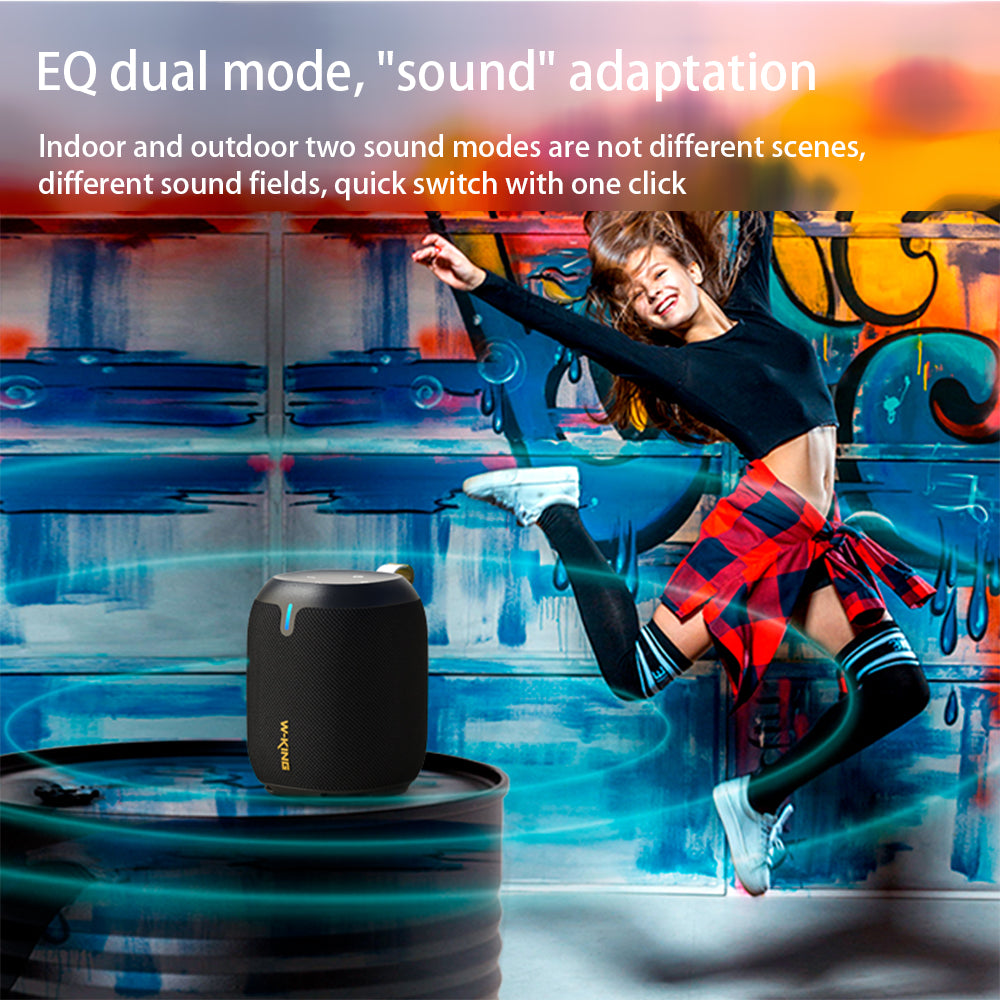 A person dancing around a black cylindrical portable Bluetooth speaker 