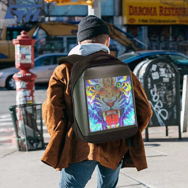 Man standing on city corner with LED backpack 