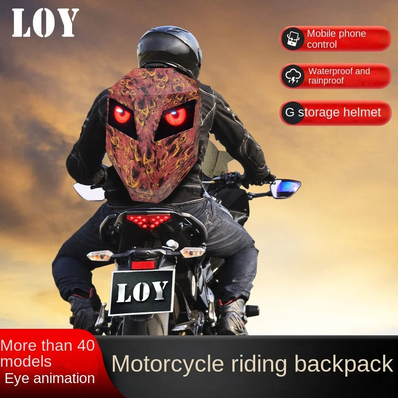 A motorcyclist is riding a motorcycle while wearing the durable ABS material LED Snakeskin Backpack from HeadphoneHeat, which features glowing red eyes and a rugged texture. Text on the image highlights features of the LOY product: mobile phone control, waterproof and rainproof, and a G storage helmet.