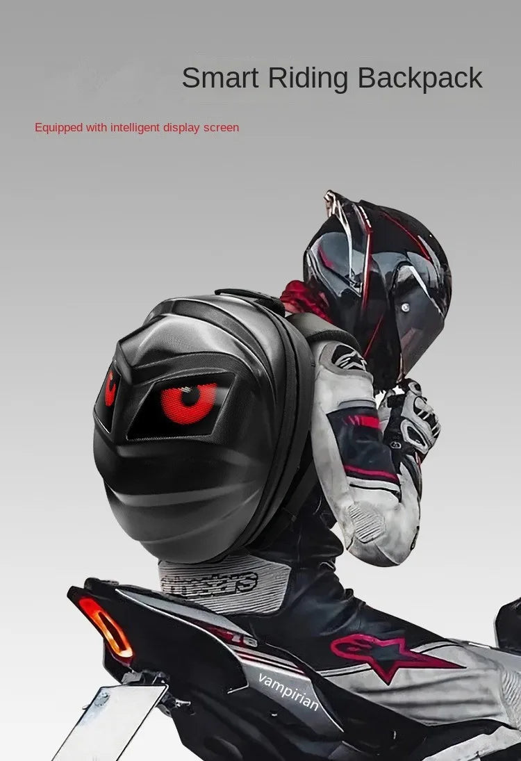 A motorcyclist in a sleek helmet and racing suit embodies the Moto & Biker Style as they ride a motorcycle, sporting a black LED Turtle Shell Backpack by HeadphoneHeat. The backpack features an animated display of large, red cartoon eyes reminiscent of Vampirina. The minimalist backdrop is a plain, light gray.