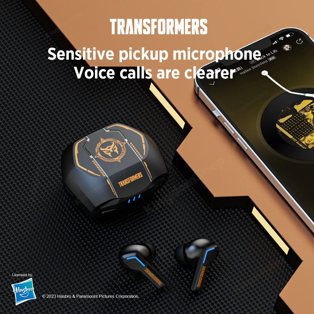 A promotional image of the HeadphoneHeat TRANSFORMERS TF-T06 TWS Bluetooth Gaming Earbuds and its charging case. The earbuds and case are black with blue and gold accents, placed on a textured surface. A smartphone is also partially visible on the upper right, showcasing a related design. Text reads, "Bluetooth 5.3. Voice calls are clearer.