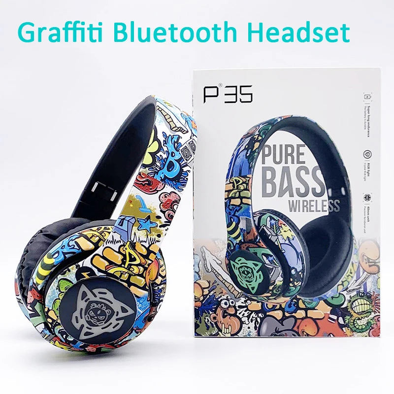 A vibrant, graffiti-themed Bluetooth headset sits beside its box, showcasing lively abstract artwork. The packaging prominently features "P35 Pure Bass Wireless with Bluetooth 5.1" alongside an image of the headset and displays "Newmsnr Graffiti Foldable Wireless Bluetooth Headphones" at the top left with the brand name HeadphoneHeat.