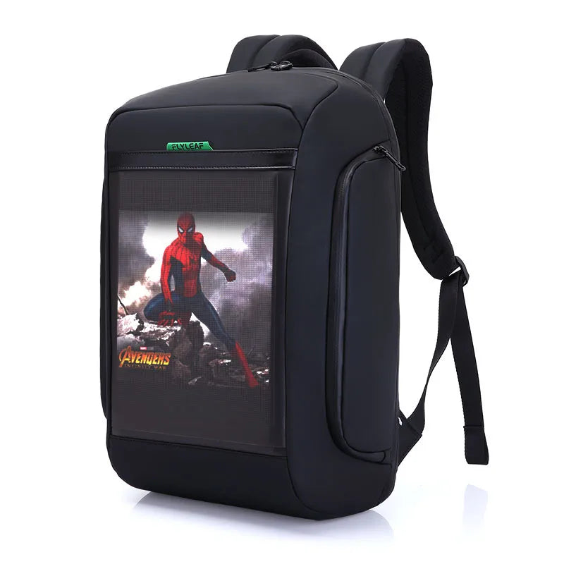 Introducing the Flashback HD Display Backpack by HeadphoneHeat: A black backpack crafted from durable polyester, showcasing a striking graphic of Spider-Man in action on the front panel. Below Spider-Man, "Avengers" is boldly printed in yellow. The backpack features padded shoulder straps, a top handle, and multiple interior compartments for organization.