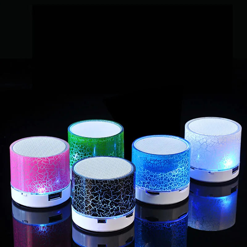 Here's a revised version of the sentence using the given product data:

Discover the XMSJ A9 Mini Portable Speaker LED and Subwoofer by HeadphoneHeat, featuring a collection of five vibrant colors—pink, green, black, blue, and white. These compact Bluetooth speakers showcase crackle-pattern designs and emit a captivating LED glow from within, elegantly presented on a reflective surface.