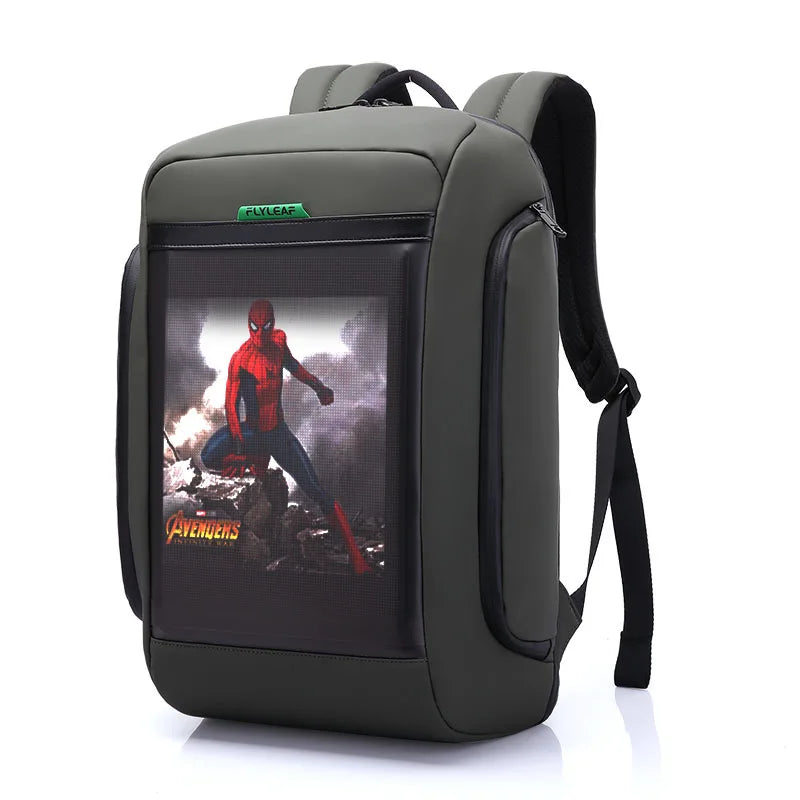 The Flashback backpack with HD Display by HeadphoneHeat is made of durable polyester and features a stylish gray and black design. The front pocket showcases a vibrant image of Spider-Man swinging with the word "Avengers" in yellow. It includes padded shoulder straps, multiple interior compartments, and boasts a sleek modern look.