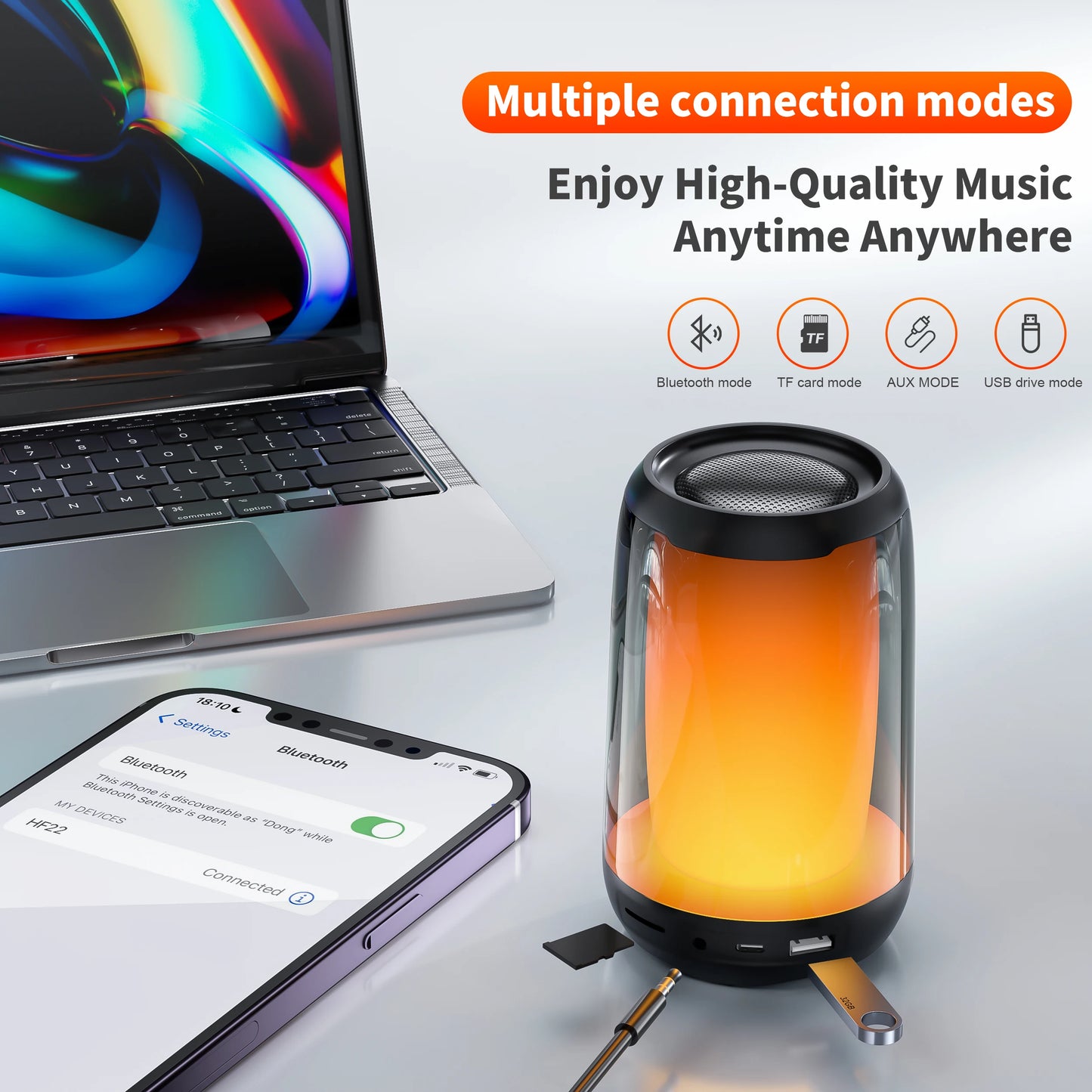 The compact, cylindrical QERE Bluetooth Speaker 5W Audio from HeadphoneHeat emits a warm orange glow beside a laptop and smartphone. This premium portable speaker supports Bluetooth, TF card, AUX, and USB drive modes, allowing you to enjoy exceptional high-quality music anytime and anywhere.